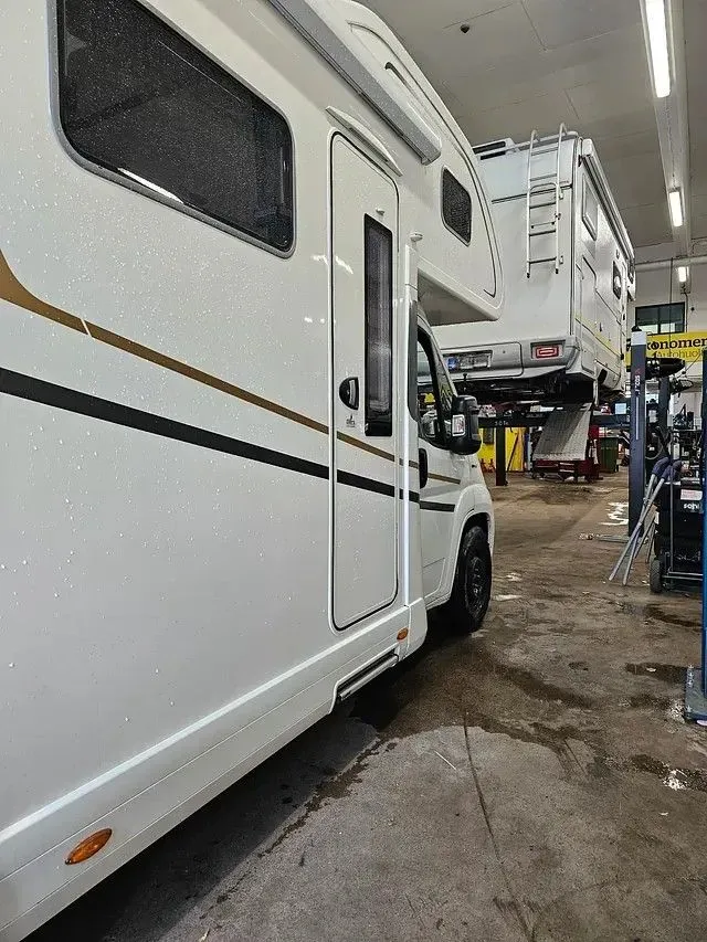 Matkailuauto korjaamohallissa huollossa